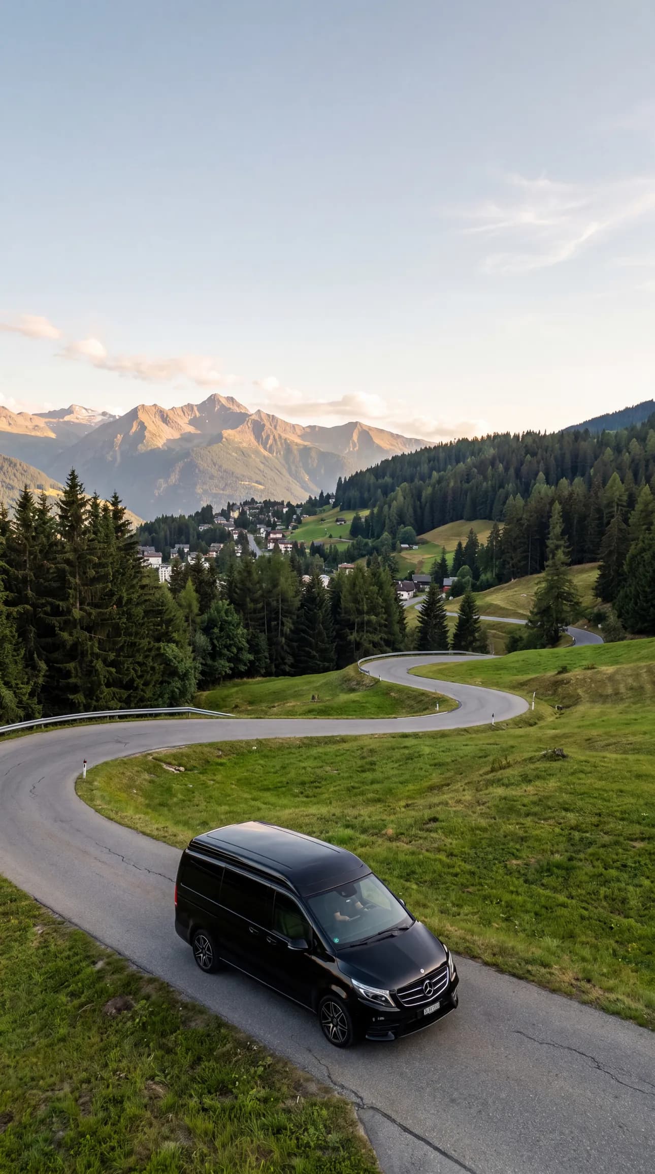 Schwarzer Mercedes-Taxivan auf einer kurvigen Bergstrasse in Crans-Montana im Sommer